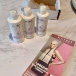 Nutree Amazonliss hair treatment kit bottles and brochure on a countertop used for frizzy hair control.